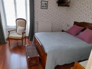 a bedroom with a bed and a chair at Chambres d'Hôtes et Table d'Hôtes- Valentine 44 in Sainte-Mère-Église