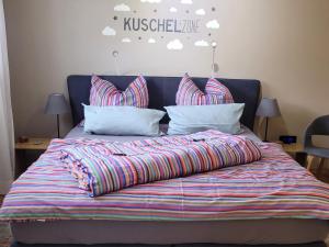 a bed with a colorful comforter and pillows at Ferienwohnung Gaß in Kastellaun