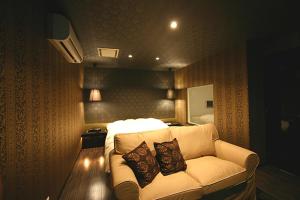 a living room with a couch with two pillows on it at Hotel VILLA ANNEX盛岡 in Morioka