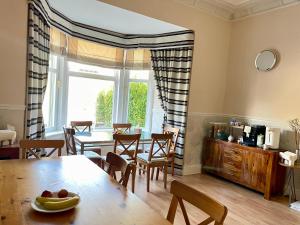 a kitchen and dining room with a table and chairs at Dalmore Lodge Guest House in Edinburgh