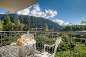 a table and chairs on a balcony with a view of mountains at Résidence Le Cristal Apartments in Chamonix +62 photos
