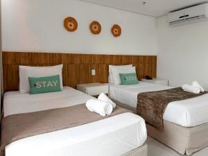 a hotel room with two beds with green pillows at STAY Cosmopolitan in Palmas