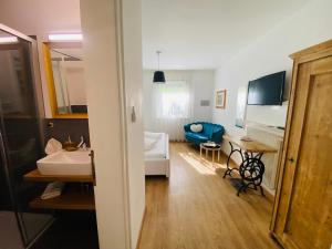 a bathroom with a sink and a living room at Hotel Garni Vinea Montis in Termeno