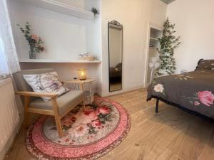 a bedroom with a bed and a chair and a mirror at Rose Cozy House in Stockton-on-Tees