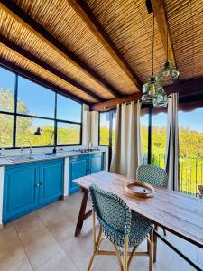 a kitchen with blue cabinets and a wooden table at Luna&Limoni Country in Muravera