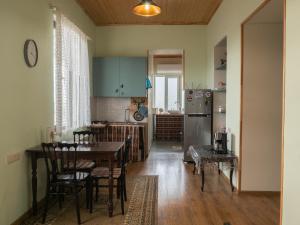 a kitchen with a table and a refrigerator at kutaisi base camp in Kutaisi