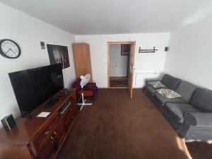 a living room with a couch and a flat screen tv at Plebanka in Grabowo