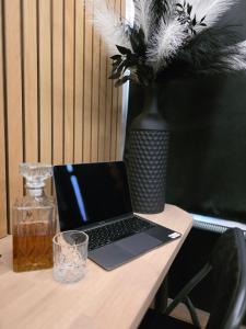 a laptop computer sitting on a table with a vase at Maison 3 chambres, jacuzzi, billard, sauna, air soccer, clim in Verviers