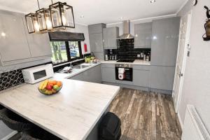 a kitchen with a bowl of fruit on a counter at Grasmere 12, White Cross Bay, Windermere in Troutbeck Bridge +5 photos