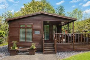 a wooden cabin with a porch and a deck at Grasmere 12, White Cross Bay, Windermere in Troutbeck Bridge