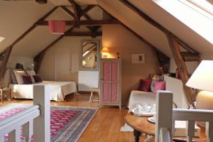 a attic room with a bed and a table at La Peuterne in Mouazé