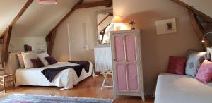 a attic room with two beds and a window at La Peuterne in Mouazé