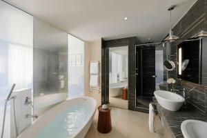 a bathroom with two sinks and a bath tub and a tub at Mandarin Oriental, Milan in Milan +124 photos