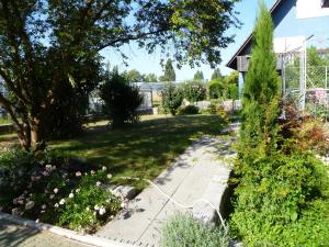 a garden with a sidewalk and a house at Villa XADAYU, Appartment in Reichenau