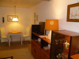 a room with a desk with a computer and a table at Villa XADAYU, Appartment in Reichenau