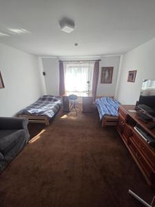 a living room with two beds and a television at Plebanka in Grabowo