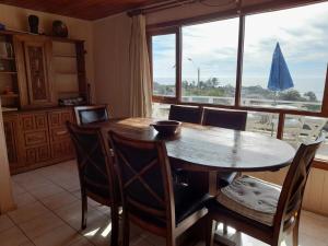 a dining room table with chairs and a large window at Tongoy península in Coquimbo +14 photos