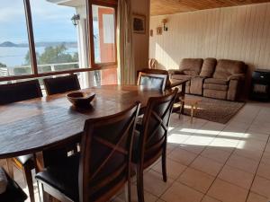 a dining room with a table and chairs and a couch at Tongoy península in Coquimbo