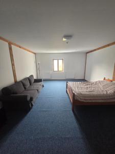 a room with a bed and a couch and a window at Plebanka in Grabowo