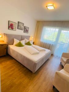 a bedroom with a large white bed with green pillows at Hotel Garni Vinea Montis in Termeno +26 photos