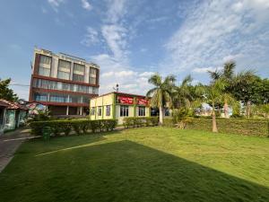 a building with a green lawn in front of a building at Hotel Picnic Garden in Patna