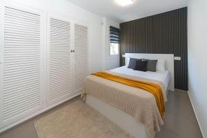 a bedroom with a bed with white walls and wooden shutters at WELCS APARTAMENTO 342 PDA con terraza in Platja d'Aro