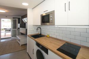 a kitchen with white cabinets and a sink at WELCS APARTAMENTO 342 PDA con terraza in Platja d'Aro