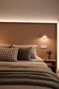a bedroom with a large bed with a wooden headboard at Pension Nagusia in Basauri +6 photos