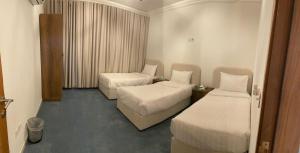 ein Zimmer mit zwei Betten in einem Hotelzimmer in der Unterkunft صدى التلال in As Sifyānī