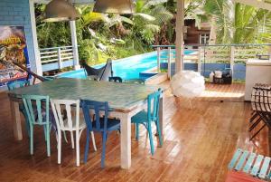 a dining room with a table and chairs and a pool at La villa bleue in Koungou