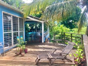 a wooden deck with a chair and a house at La villa bleue in Koungou
