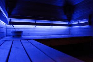 a dark room with a blue light on a bench at Jacuzzi Loft in the Center of Riga in Riga