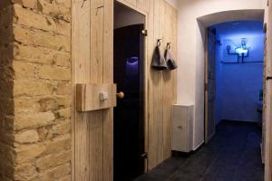 a hallway with a wooden door and a brick wall at Jacuzzi Loft in the Center of Riga in Riga