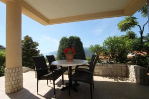 a table and chairs on a patio with a view at V Apartment in Rabac