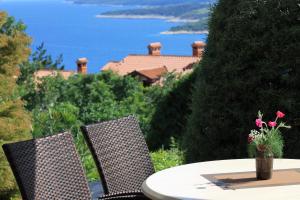 a table with two chairs and a vase with flowers at V Apartment in Rabac +3 photos