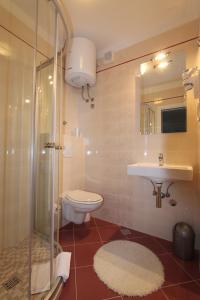 a bathroom with a toilet and a sink and a shower at V Apartment in Rabac