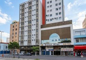 a tall building with a solar flat hotel on a street at Solar Flat Hotel in Juiz de Fora