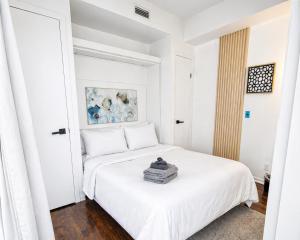 a white bedroom with a large white bed at 2 Bedroom Condo With City Views and Free Parking in Toronto
