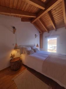 a bedroom with a large bed and a window at Alba Odeceixe - casa clara in Odeceixe