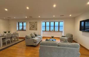 a living room with two couches and a dining room at Whitehall Farm in Caerleon