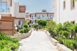 a person walking down a walkway between buildings at Sirios Village Hotel & Bungalows - All Inclusive in Kato Daratso