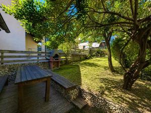 a wooden bench sitting on a deck next to a tree at Rose Cottage in Bovec