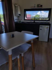 a table and chairs in a kitchen with a window at Cabañas PxA in Villa Anizacate