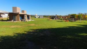 a large yard with a house in the background at Cabañas PxA in Villa Anizacate