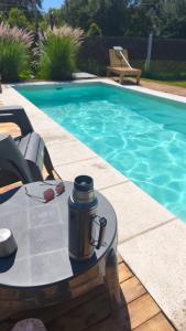 a tea kettle on a table next to a swimming pool at Cabañas PxA in Villa Anizacate