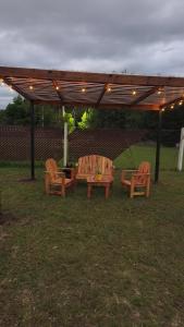 two wooden chairs and a table under a pergola at Cabañas PxA in Villa Anizacate +2 photos