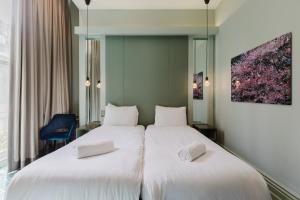 two beds in a hotel room with white sheets at The Lancaster Hotel in London