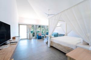 a bedroom with a bed and a tv in a room at Marbela Beach Resort in Morjim