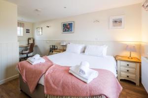 a bedroom with a bed with two towels on it at Sanctuary House in Thorpeness