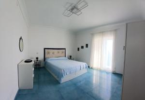 a white bedroom with a bed and a window at Venti In Costa in Furore